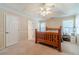 Spacious bedroom with carpet, natural light, and a modern ceiling fan at 704 Stonecrest Ln, Loganville, GA 30052