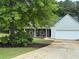 Charming home with a well-maintained lawn, lush trees, and a welcoming two-car garage at 704 Stonecrest Ln, Loganville, GA 30052