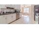 Well-lit kitchen features white cabinetry, stainless steel appliances, and adjacent dining area at 704 Stonecrest Ln, Loganville, GA 30052