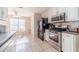 Bright kitchen with stainless steel appliances, white cabinets, and tile flooring at 704 Stonecrest Ln, Loganville, GA 30052