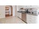 Well-lit kitchen with white cabinets and stainless steel appliances, seamlessly connected to the hallway at 704 Stonecrest Ln, Loganville, GA 30052