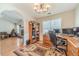 Inviting office space with a chandelier, desk, and views into the living room with a fireplace at 704 Stonecrest Ln, Loganville, GA 30052