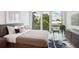 Sunlit bedroom featuring modern furnishings, stylish decor, and a large window with a neighborhood view at 775 Juniper St # 405, Atlanta, GA 30308