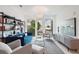 Bright living room with stylish blue sofa, modern shelving unit, and large windows showcasing city views at 775 Juniper St # 405, Atlanta, GA 30308