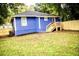 Bright blue home showcasing a spacious backyard with a wooden fence and grassy lawn at 836 Wood Nw St, Atlanta, GA 30318