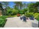 Picturesque backyard featuring a patio, fire pit, seating, mature trees, and lush greenery at 916 Stratford Rd, Avondale Estates, GA 30002
