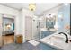 Bright bathroom featuring gray tile floors, blue cabinets, a glass shower, and a stylish chandelier at 916 Stratford Rd, Avondale Estates, GA 30002