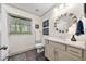 Bathroom featuring a stylish round mirror, quartz countertop, and a window view for a bright and airy feel at 916 Stratford Rd, Avondale Estates, GA 30002