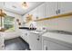 Well-lit laundry room with white cabinets, black countertops, modern washer and dryer, and hexagon tile floor at 916 Stratford Rd, Avondale Estates, GA 30002