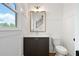 Well-lit powder room with a dark vanity, gold mirror, and tile floors at 002 Wakehurst Way, Marietta, GA 30064