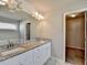 Bathroom vanity with granite countertop, dual sinks, large mirror, and a walk-in closet at 4421 Fulson Dr, Lilburn, GA 30047