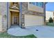 Inviting front entrance with a covered porch, sidelights, and an attached garage, offering curb appeal at 4421 Fulson Dr, Lilburn, GA 30047