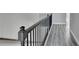 Modern hallway with gray wood floors and black metal railing at 4421 Fulson Dr, Lilburn, GA 30047