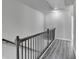 Modern hallway with gray wood floors and black metal railing at 4421 Fulson Dr, Lilburn, GA 30047