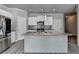Well-lit kitchen with stainless steel appliances, large island, mosaic backsplash, and modern white cabinets at 4421 Fulson Dr, Lilburn, GA 30047