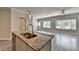 Kitchen with granite countertop island that opens to bright living room with big windows at 4421 Fulson Dr, Lilburn, GA 30047
