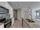 Bright kitchen with stainless appliances, granite countertops, and view into adjacent living space at 4421 Fulson Dr, Lilburn, GA 30047