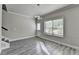 Entry room featuring gray wood floors, white trim, a door to the outside, and modern light fixture at 4421 Fulson Dr, Lilburn, GA 30047