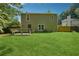 A spacious backyard with a well-maintained lawn, patio, wooden bench and trees at 6223 Marbut Farms Ln, Lithonia, GA 30058