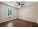 Bedroom featuring hardwood floors, neutral walls, and large window overlooking the yard at 6223 Marbut Farms Ln, Lithonia, GA 30058