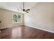Spacious bedroom with a ceiling fan, hardwood floors, and a large window offering plenty of light at 6223 Marbut Farms Ln, Lithonia, GA 30058