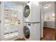 Convenient laundry room features a stackable washer and dryer next to a bright windowed door at 653 N Highland Ne Ave # 5, Atlanta, GA 30306