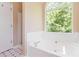 Bright bathroom featuring a soaking tub beneath a window and a separate shower at 7186 Raintree Loop, Jonesboro, GA 30236