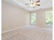 Bedroom featuring tray ceilings, carpeted floors, and large windows at 7186 Raintree Loop, Jonesboro, GA 30236