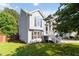 Side view of charming two-story home with green lawn, black shutters, and classic architectural details at 7186 Raintree Loop, Jonesboro, GA 30236