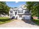 Inviting two-story home with gray siding, black shutters, manicured lawn, and an attached one car garage at 7186 Raintree Loop, Jonesboro, GA 30236