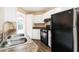 Functional kitchen with white cabinetry, a modern sink, and black appliances at 7186 Raintree Loop, Jonesboro, GA 30236