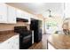 Bright kitchen features white cabinets, black appliances, and a dining area, creating a cozy space at 7186 Raintree Loop, Jonesboro, GA 30236