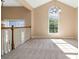 Upstairs living area featuring carpet, a chandelier, staircase, and arched window letting in plenty of light at 7186 Raintree Loop, Jonesboro, GA 30236