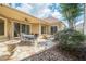 Charming covered patio with stone flooring, outdoor dining set, and fire pit, providing a cozy outdoor living space at 308 Rusty Gate Pass, Woodstock, GA 30189