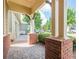 Covered porch with brick columns, stone flooring and manicured hedges provides a welcoming outdoor space at 308 Rusty Gate Pass, Woodstock, GA 30189