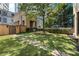 A well-manicured backyard featuring lush green grass, decorative stone pathways and a central tree at 3376 Peachtree Rd # 1, Atlanta, GA 30326