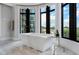 Modern soaking tub with cityscape views through expansive windows bringing in lots of natural light at 3376 Peachtree Rd # 1, Atlanta, GA 30326