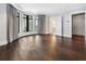 Expansive bedroom with dark hardwood floors, curved windows, and a glimpse into an attached bathroom at 3376 Peachtree Rd # 1, Atlanta, GA 30326