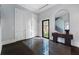 An inviting foyer with dark wood floors, a mirror, and a glimpse of the outdoors through a glass door at 3376 Peachtree Rd # 1, Atlanta, GA 30326