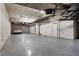 Spacious garage with a white car parked inside, featuring concrete walls and ceiling and multiple doors at 3376 Peachtree Rd # 1, Atlanta, GA 30326