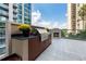 Outdoor kitchen with built-in grill, granite countertops, and an outdoor fireplace overlooking city views at 3376 Peachtree Rd # 1, Atlanta, GA 30326