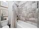 This is an interior shot of a bathroom showcasing a bathtub and toilet with stone-look tile surround at 4440 Atwood Dr, Cumming, GA 30040
