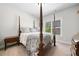 Bedroom with carpet, a wooden four-poster bed with nice pillows and a window overlooking the backyard at 4440 Atwood Dr, Cumming, GA 30040