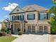 Charming two-story home with white brick, shuttered windows, and two-car garage at 4440 Atwood Dr, Cumming, GA 30040