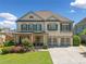 Charming two-story home with white brick, shuttered windows, two-car garage, and professionally landscaped front yard at 4440 Atwood Dr, Cumming, GA 30040