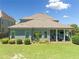 Beautiful home exterior features a covered patio with outdoor seating, grill, and manicured lawn with garden beds at 4440 Atwood Dr, Cumming, GA 30040