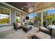 Covered patio with cozy seating, ceiling fan, TV, grill, and green egg, perfect for outdoor entertaining at 4440 Atwood Dr, Cumming, GA 30040
