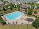 A large community pool is surrounded by lounge chairs, tables with umbrellas, and a two-story building at 4440 Atwood Dr, Cumming, GA 30040