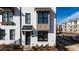 Close-up of a modern townhome featuring white brick, gray accents, a dark front door, and a cozy entrance at 506 Healy Dr # 74, Cumming, GA 30040
