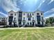 Charming townhome featuring a modern facade and well-manicured lawn, perfect for comfortable and stylish living at 506 Healy Dr # 74, Cumming, GA 30040